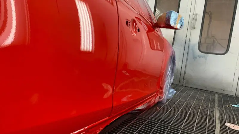 The same red car in the spray booth after the door was repaired and resprayed, Dublin